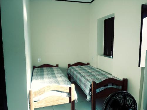 ein Zimmer mit 2 Betten und einem Stuhl darin in der Unterkunft Pousada Tio Sinhô e Tia Sinhá in Rio de Contas