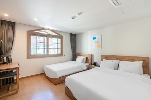 Una cama o camas en una habitación de Heyy Seogwipo Hotel