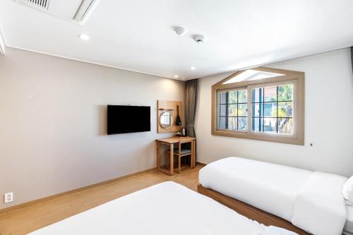 Una cama o camas en una habitación de Heyy Seogwipo Hotel