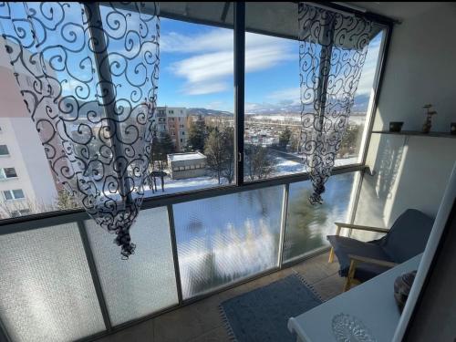a room with a large window with a view of a city at Svit apartment High Tatras in Svit