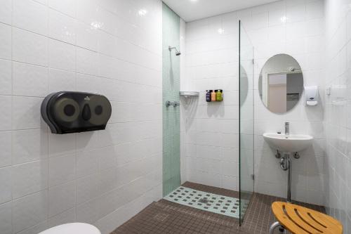 a bathroom with a shower and a toilet and a sink at Tequila Sunrise Hostel Sydney in Sydney