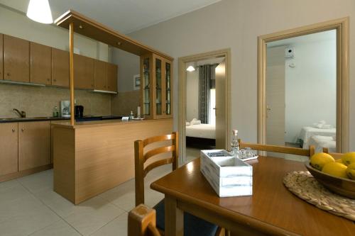 a kitchen and dining room with a table with a bowl of fruit at Elaionas Studios in Gythio