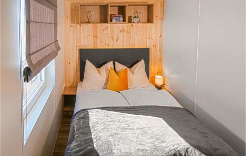 a bed with orange pillows in a small room at Wildkraeuterweg 1 in Gottsdorf