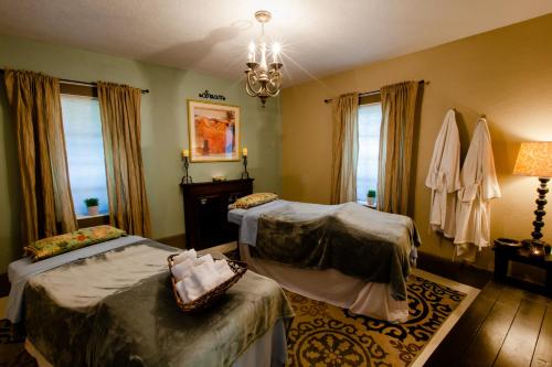 a bedroom with two beds and a chandelier at Strawberry Valley Inn in Mount Shasta