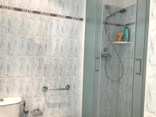 ein Bad mit einer Dusche und weißen Fliesen in der Unterkunft 4 Pers Centrale WiFi in Nizza