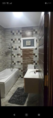 La salle de bains est pourvue d'une baignoire, de toilettes et d'un lavabo. dans l'établissement مدينه نصر مكرم عبيد, au Caire
