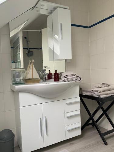 ein Badezimmer mit einem weißen Waschbecken und einem Spiegel in der Unterkunft Ferienwohnung Fleckeby Schlei Fjord Light in Fleckeby