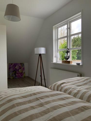 a white bedroom with two beds and a window at Ferienwohnung Fleckeby Schlei Fjord Light in Fleckeby