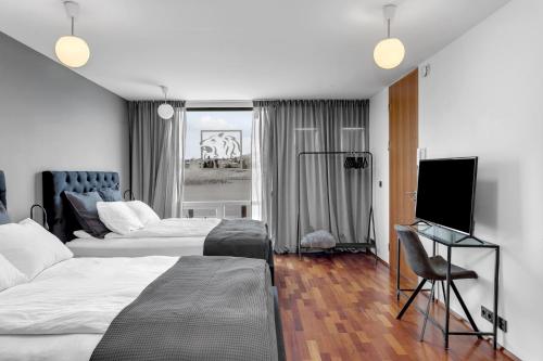 1 Schlafzimmer mit 2 Betten und einem Flachbild-TV in der Unterkunft Studio Apartment with Ocean View in Reykjavík