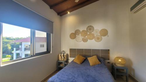 a bedroom with a bed and a large window at Condo Golf B3 F3 Hacienda Iguana in Tola