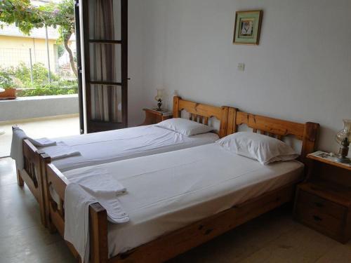um quarto com 2 camas e lençóis brancos em Paradise Inn em Milatos