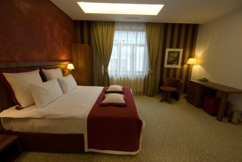 a hotel room with a large bed and a window at Hotel Gott in Braşov