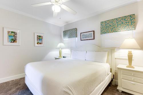 a white bedroom with a white bed and two lamps at Waterscape B628 in Fort Walton Beach