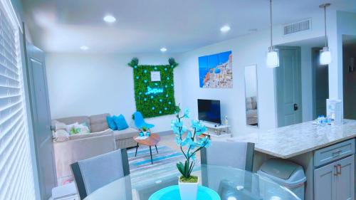 uma cozinha e sala de estar com uma mesa de vidro em Modern Santorini Suite Houston NRG TMC Luxurious Walkable em Houston
