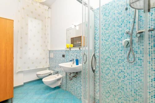 a blue tiled bathroom with a sink and a toilet at Lerici 5 Terre casa il Bivio 1989 in Lerici