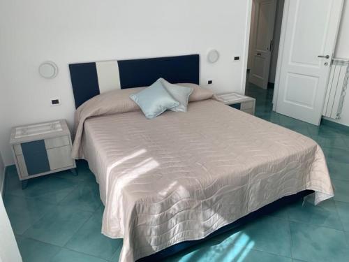 1 dormitorio con 1 cama grande y cabecero azul en Casa Ausilia Trilocale, en Amalfi
