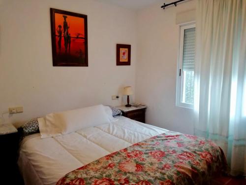 Un dormitorio con una cama con una manta floral. en Casa el Acebuche, en Cazorla