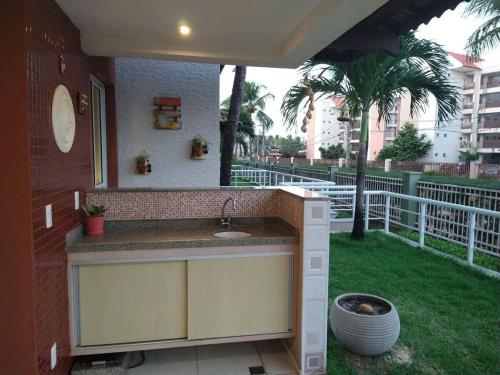 a outdoor kitchen with a sink in a backyard at Porto das Dunas paraíso 300m do Beach Park in Aquiraz