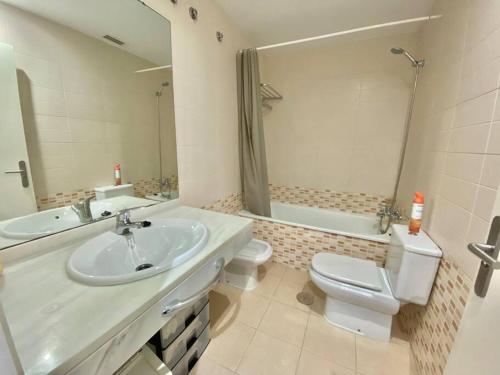 łazienka z umywalką, toaletą i lustrem w obiekcie Apartamento nuevo con piscina, temporada w mieście El Puerto de Santa María