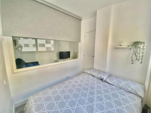 sypialnia z łóżkiem i oknem w obiekcie Apartamento nuevo con piscina, temporada w mieście El Puerto de Santa María
