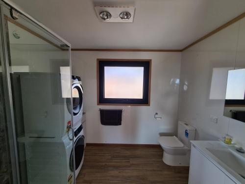 uma casa de banho com um lavatório e uma máquina de lavar roupa em Mount Rumney Escapes - 4 Seaview Devil House em Mount Rumney
