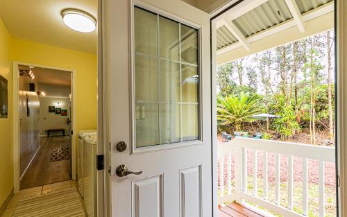 a door to a balcony with a view of a yard at Hawaiian Plantation Style Home in Mountain View in Mountain View