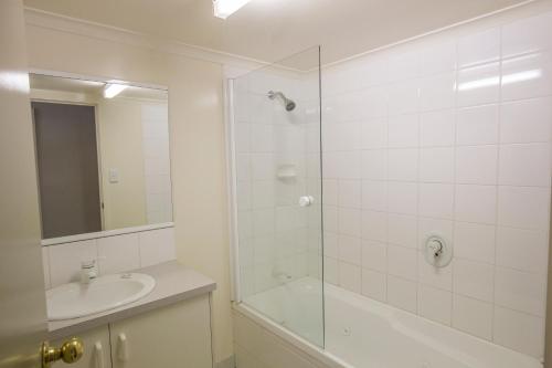 a white bathroom with a shower and a sink at Winter Getaway in Methven
