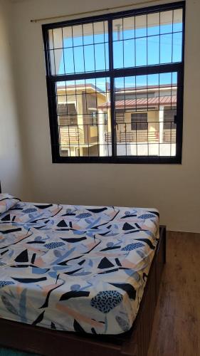 a bed in a room with a large window at Camilyn Home Stay in General Trias
