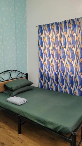 uma cama num quarto com um colchão verde em Camilyn Home Stay em General Trias
