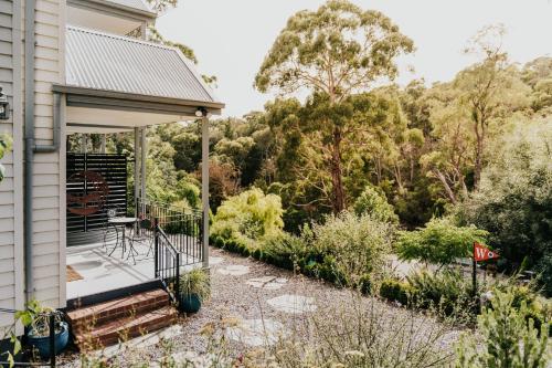 a house with a deck with a view of the forest at Ascona - Hepburn Springs Daylesford in Hepburn Springs
