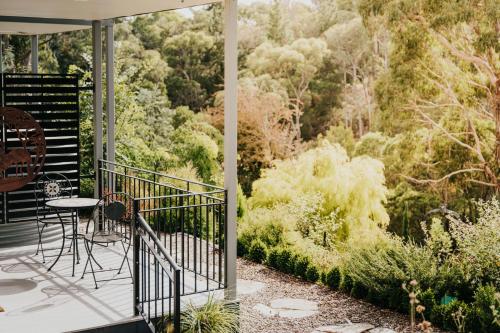 a balcony with a table and chairs and trees at Ascona - Hepburn Springs Daylesford in Hepburn Springs