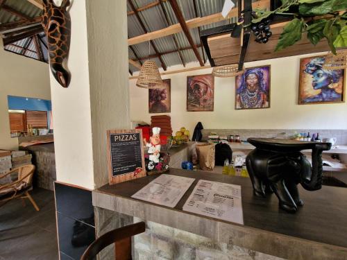 a restaurant with a table and a giraffe on the counter at Asamai Villas in Sifoe