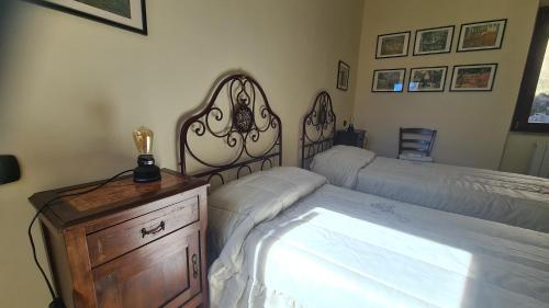 a bedroom with a bed and a wooden dresser with a bedskirts at Amazing Lake View in Castel di Tora