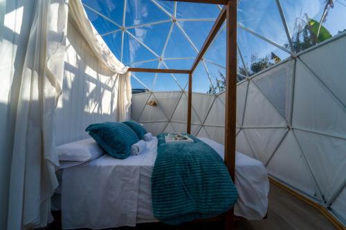 Habitación con cama en una tienda de campaña en la cúpula en ADAMA Glamping, en Chiclana de la Frontera