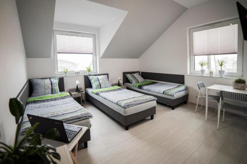 Pokój z 2 łóżkami, stołem i oknami w obiekcie Viva Noclegi w Bielsku Białej