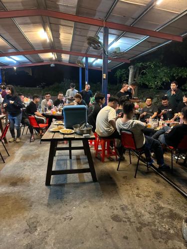 een groep mensen die aan tafel zitten in een restaurant bij 蓬萊生態農場仙山民宿 in Nanzhuang