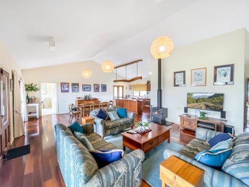 a living room with blue couches and a table at Midnight's Promise - Promise 2 in Lovedale