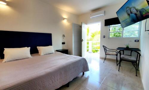 a bedroom with a bed and a table and a window at Cozumel 400A - Vacation Rental in Cozumel
