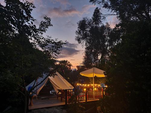 a tent with a table and a yellow umbrella at Glamping Portal Del Bosque in Pacho