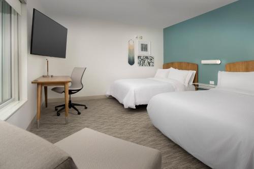 a hotel room with two beds and a desk at Element Portland Beaverton in Beaverton