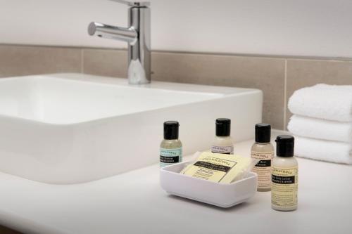 a bathroom counter with three bottles of soap and a sink at Element Portland Beaverton in Beaverton