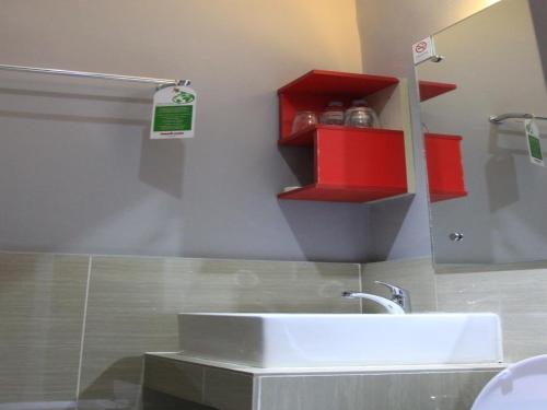 a bathroom with a white sink and a mirror at Sumo Asia Hotels - Davao in Davao City