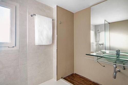 a bathroom with a glass sink and a shower at AC Hotel La Línea by Marriott in La Línea de la Concepción