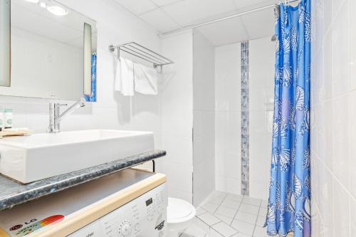 a white bathroom with a sink and a toilet at Bayview Tower in Yeppoon