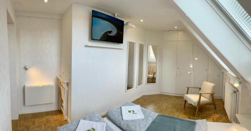 Habitación con cama y TV en la pared. en bedinBERN Aparthotel, en Berna