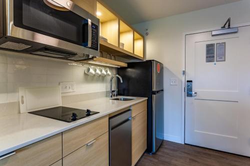 a kitchen with a microwave and a refrigerator at TownePlace Suites by Marriott Raleigh - University Area in Raleigh
