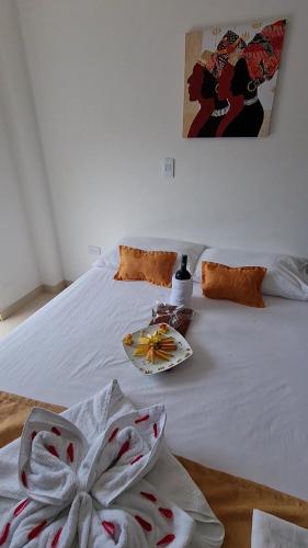 a white bed with a plate on top of it at Ecohotel Linda Judith in Bahía Solano