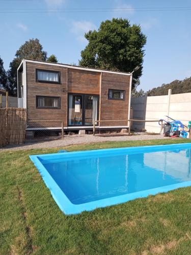 een tiny house met een zwembad in de tuin bij Tinny cabañas estación ritoque in Quintero