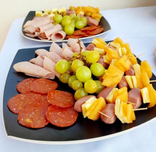 two plates of food on a table with grapes and meats at Hotel La Lejona in San Miguel de Allende