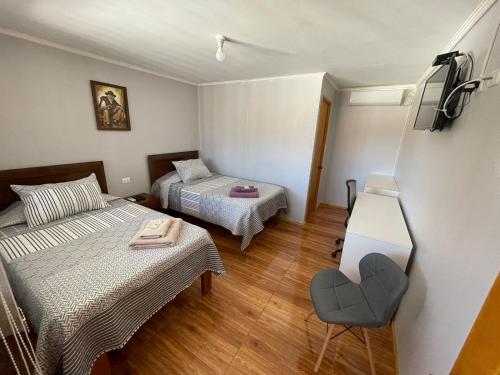 um quarto com duas camas e uma cadeira em Hotel Hambyll,,,,,,,,,,,,,,,,,,,, em Diego de Almagro